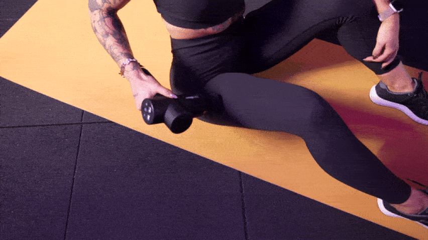 Upotreba masažnog pištolja na vanjskoj strani bedara Upotreba masažnog pištolja na vanjskoj strani bedara